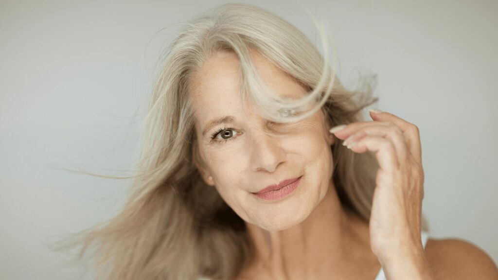 Femme d’âge mûr ressentant les symptômes de la ménopause comme les bouffées de chaleur et les perturbations hormonales, accompagnement naturel avec LaserAddict.