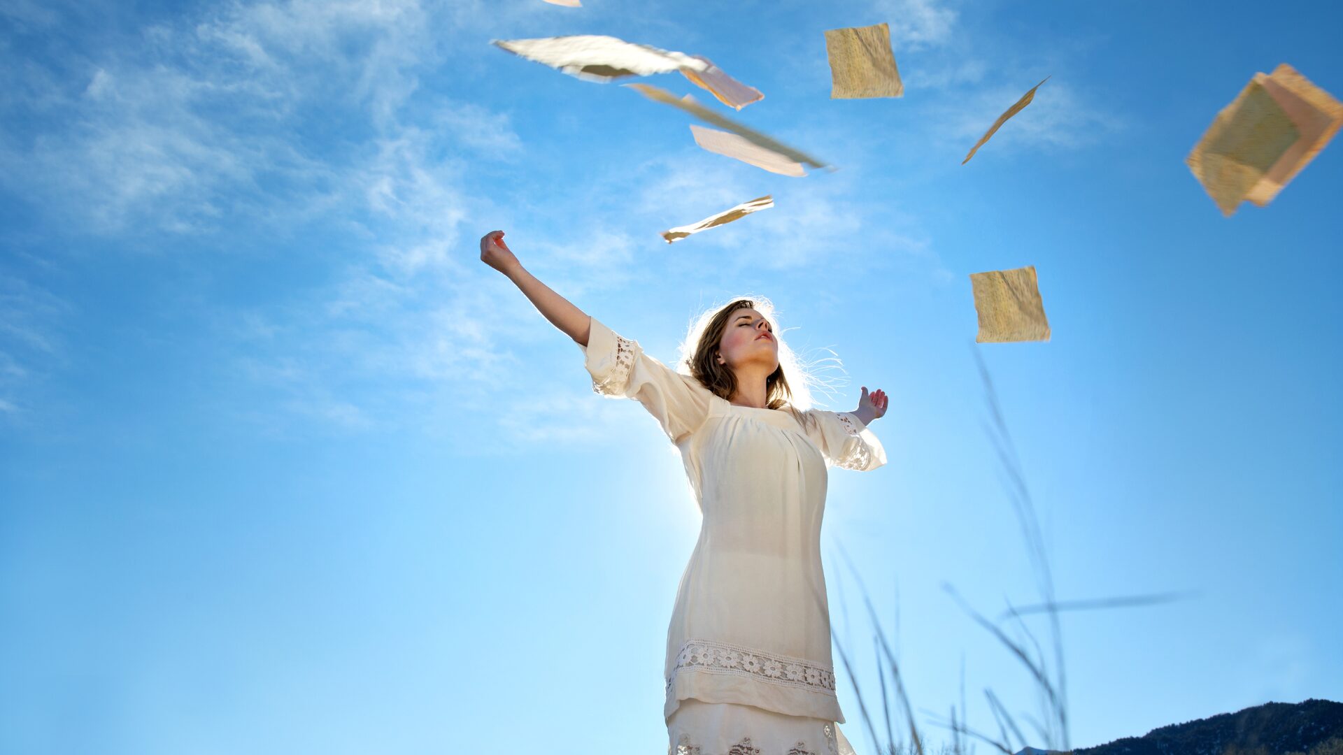 Femme souriante lâchant des papiers au vent, symbolisant le lâcher-prise et la libération du stress avec LaserAddict